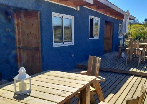 een blauw huis met een houten tafel op een terras bij Espacio lagunillas Alojamiento in Lagunillas