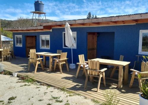 een blauw huis met een tafel en stoelen en een parasol bij Espacio lagunillas Alojamiento in Lagunillas