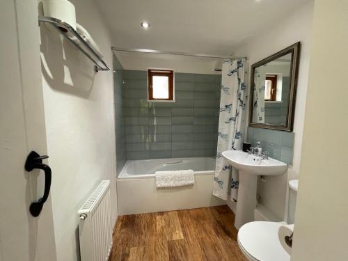 a bathroom with a tub and a sink and a toilet at Lovely Somerset Getaway in Taunton
