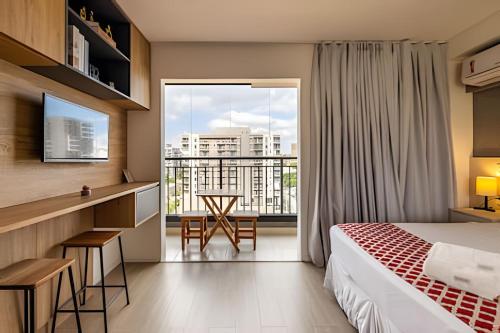 a hotel room with a bed and a large window at Studio mobiliado ao lado do aeroporto de Congonhas in Sao Paulo