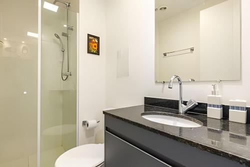 a bathroom with a sink and a toilet and a mirror at Studio mobiliado ao lado do aeroporto de Congonhas in Sao Paulo