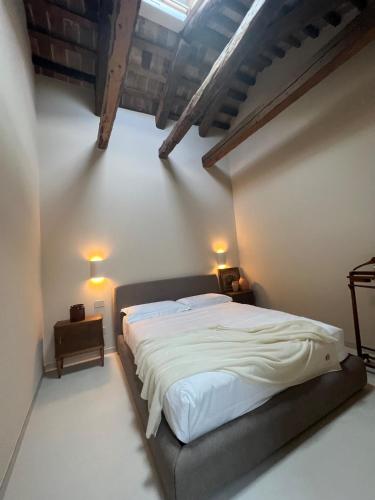 a bedroom with a large bed with white sheets at Can Los arcos in Chioggia