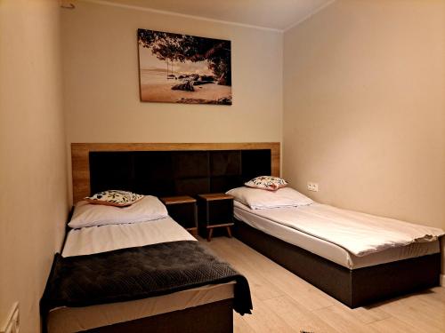 a room with two beds and a picture on the wall at APARTAMENT MIERZYN in Międzychód
