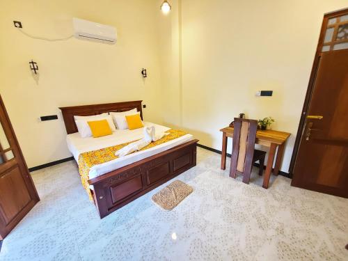 a bedroom with a bed and a desk and a table at AfterFly in Ahangama