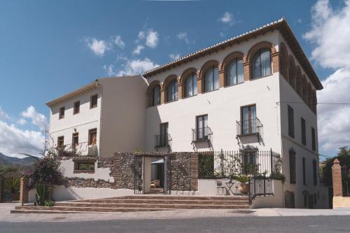 a large white building with windows and stairs at Elysium Boutique Hotel & Restaurant in Melegis