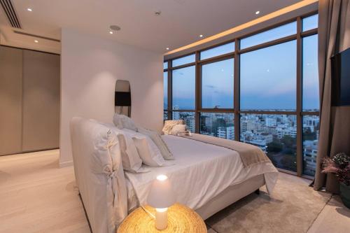 une chambre avec un grand lit et une grande fenêtre dans l'établissement SAFFRON, à Nicosie