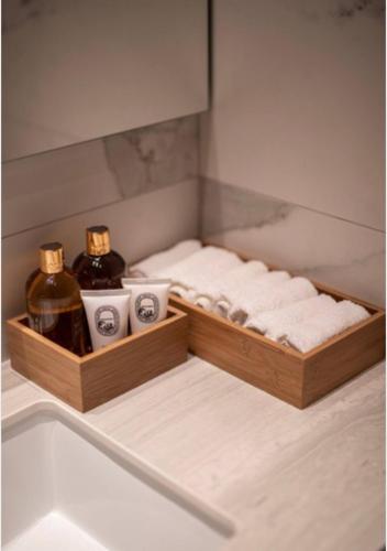 a wooden tray with two bottles of soap and towels at Saffron Suite by Tangerine in Nicosia