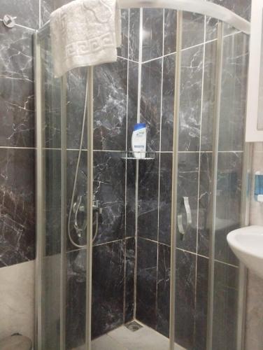 een badkamer met een douche en een zwart betegelde muur bij Şişli Suites - Room47 in Istanbul