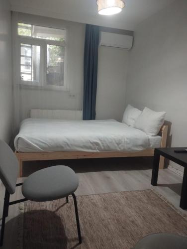 een slaapkamer met een bed, een raam en een stoel bij Şişli Suites - Room47 in Istanbul