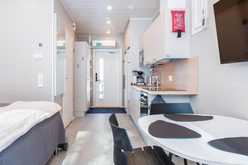 eine kleine Küche mit Tisch und Stühlen in einem Zimmer in der Unterkunft Halla Chalet, Northern Lights, ski & lake, free wifi, Vuosseli Resort Ruka in Kuusamo