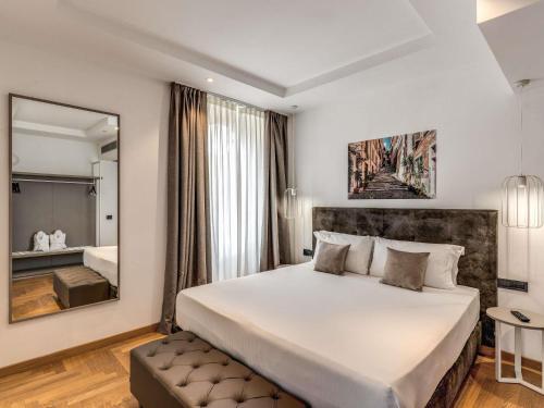 a bedroom with a large bed and a mirror at Mercure Roma Centro Termini in Rome