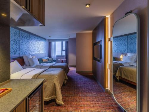 a hotel room with two beds and a tv at Mercure Trabzon Hotel in Trabzon
