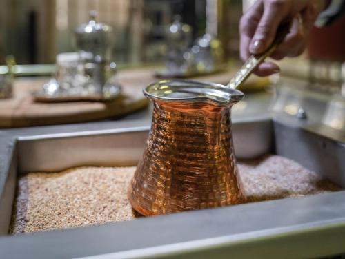 Una persona está poniendo condimento en una botella en un fregadero. en Mercure Trabzon Hotel, en Trabzon