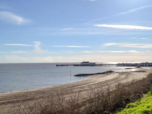 a beach with a pier in the water at Praise Machine Caravan Experience in Jaywick Sands
