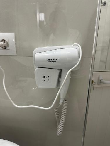 a white hairdryer on a wall in a bathroom at Mimani Stone House Roshnik in Roshnik