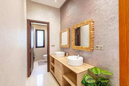 ein Badezimmer mit zwei Waschbecken und einem Spiegel in der Unterkunft Comfortable villa with heated pool in Marrakesch