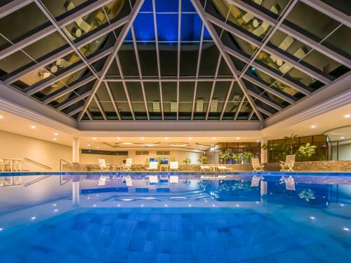 Una gran piscina en un hotel con un gran techo. en ibis Styles Sorocaba Santa Rosalia, en Sorocaba