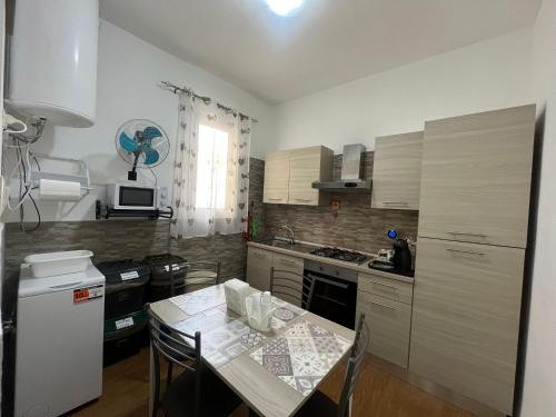 アウグスタにあるLa Petite Maisonのキッチン(テーブル、椅子、白い冷蔵庫付)