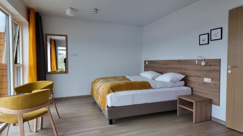 a bedroom with a bed and a table and a chair at Hotel 1001 Nott in Egilsstadir