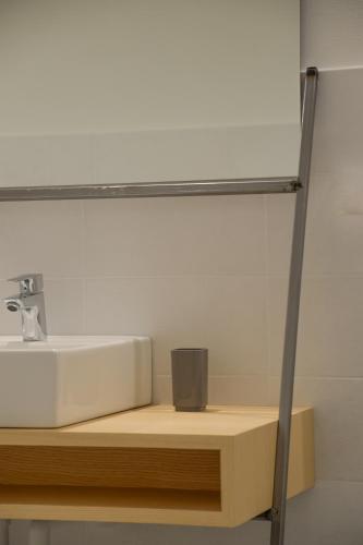a bathroom sink on a wooden shelf with a mirror at Piano Tre in Verona