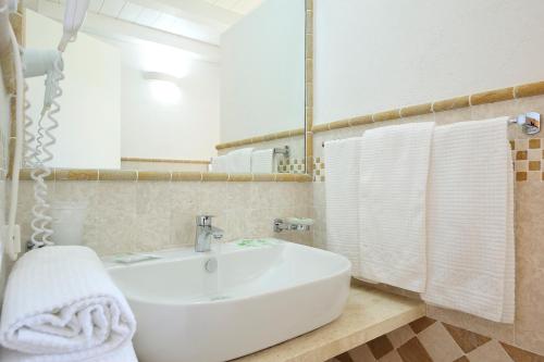 a bathroom with a sink and a mirror and towels at Cala Fiorita in Agrustos