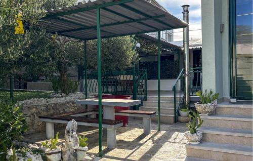 a picnic table and bench under an umbrella on a patio at Awesome Apartment In Duce With House Sea View in Duće