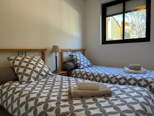 Un dormitorio con dos camas y una ventana en Kôté Sea Apartment, en Seignosse