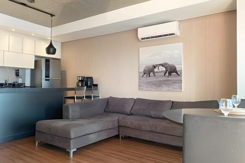 a living room with a couch and two elephants at Geo Berrini Residences in Sao Paulo