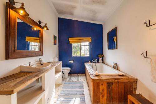 a blue bathroom with two sinks and a tub at Sanctuary Farm House 5-bedroom Lodge In Wildlife in Naivasha