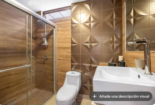 a bathroom with a shower and a toilet and a sink at Vita House in Quito