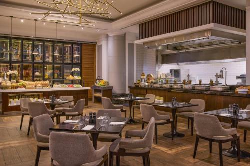 un restaurant avec des tables et des chaises et une cuisine dans l'établissement Brisbane Marriott Hotel, à Brisbane