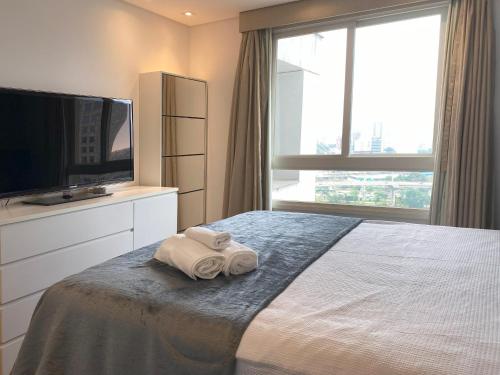 a bedroom with a bed with two towels on it at Geo Berrini Residences in Sao Paulo
