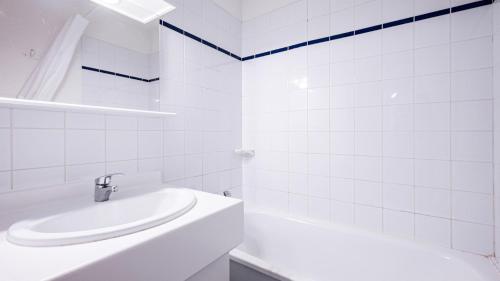 a white bathroom with a sink and a tub at Les Eterlous N24 2P6 in Morillon