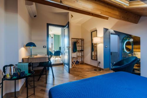 a bedroom with a blue bed and a desk at Palazzo Pastura B&B and Apartments in Catania