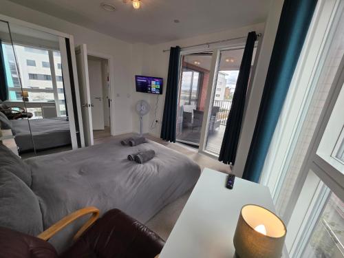 a bedroom with a bed and a table and a couch at 3 Bedroom apartment from F&A properties in North Woolwich