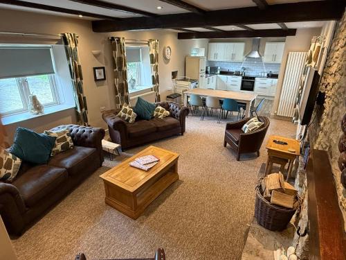 a living room with couches and a table and a kitchen at Tuckers Grave Inn - Historic Inn & Cider Pub in Norton Saint Philip