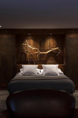 a bedroom with a large bed with a wooden wall at Le Clos Des Sens in Annecy