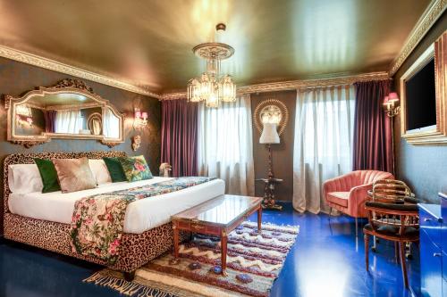 a living room with a bed and a chandelier at Glam Taoo Hotel Apartamento Boutique in Lugo