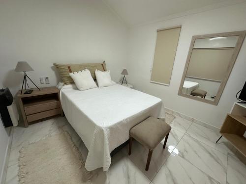 een witte slaapkamer met een groot bed en een spiegel bij COMPLEJO JONAS SALK - departamento de 1 dormitorio amoblado in San Francisco