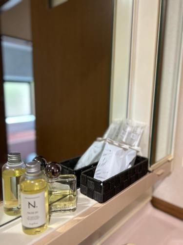 a bathroom counter with two jars and a mirror at アットホーム五島 in Goto