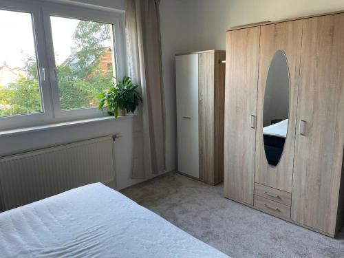 a bedroom with a bed and a dresser and a mirror at Gemütliche 2-Zimmerwohnung in Schönefeld