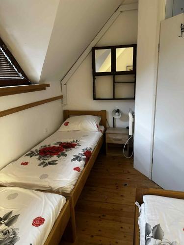 a small bedroom with two beds in a attic at Melisa's Holiday Home with pool tickets in Mostec