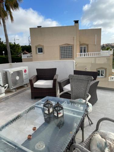 a patio with a glass table and chairs at Villa balcones in Los Altos