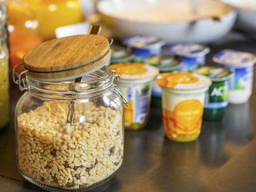 un frasco de cacahuetes sentado en una mesa con otros alimentos en Mercure Krakow Fabryczna City, en Cracovia