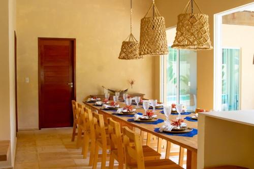 einen Esstisch mit Stühlen und einem langen Tisch in der Unterkunft Villa Bella - São Miguel do Gostoso in Touros