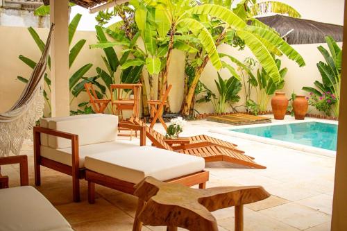 eine Terrasse mit Stühlen und einem Swimmingpool in der Unterkunft Villa Bella - São Miguel do Gostoso in Touros