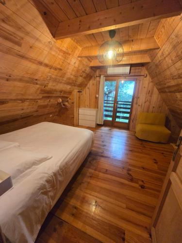 a bedroom with a bed in a wooden cabin at Lodge du Parc des Combes avec Accès Parc inclus selon calendrier ouverture Parc in Le Creusot
