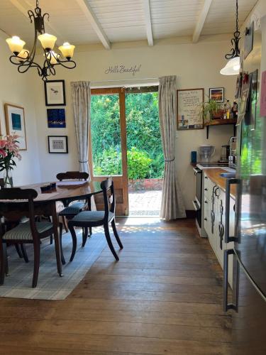 a kitchen and dining room with a table and a window at amelie, urban retreat awaits in Nelson