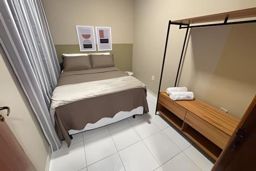 a small bedroom with a bed and a mirror at Apê espaçoso e tranquilo pertinho do centro! in Barreiras