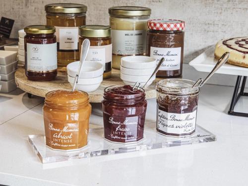Una exhibición de frascos de mermelada en un mostrador con postres. en Mercure Belfort Centre, en Belfort
